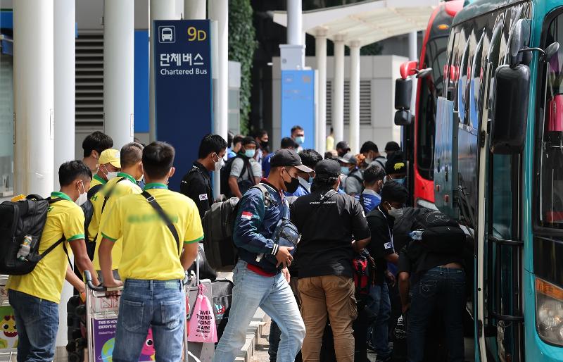 バスに乗る外国人労働者たち＝２０日、仁川国際空港、聯合ニュース