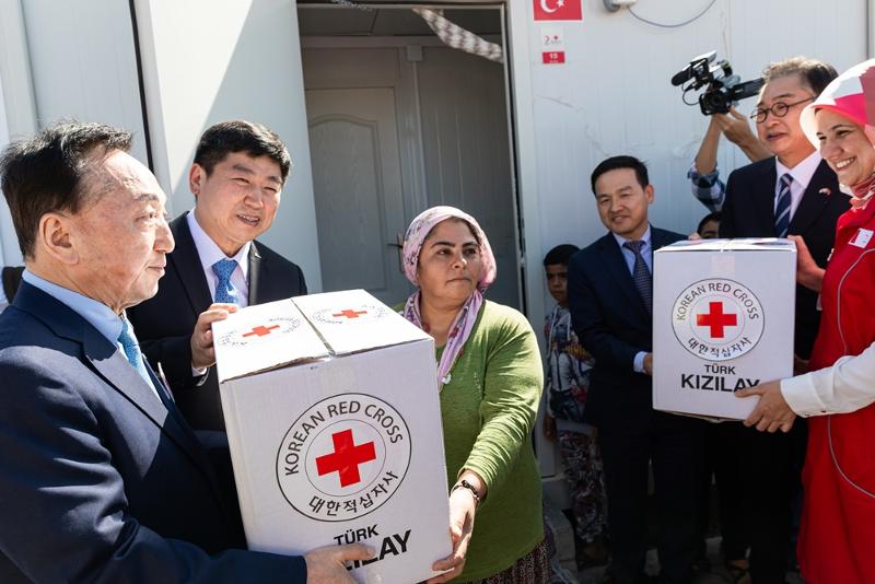「韓国・トルコ 友情の村」の入居式で大韓赤十字社のキム・チョルス会長が現地の住民に日用品を渡す様子＝７日（現地時間）、トルコ