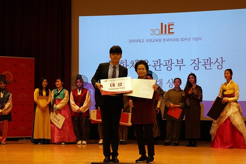 「第２５回世界外国人スピーチ大会」で、アン・ヨンス審査委員長（右）と大賞を受賞したタム・ソスン（中国）氏が記念撮影を行う様子＝１９日、ソウル東大門区 