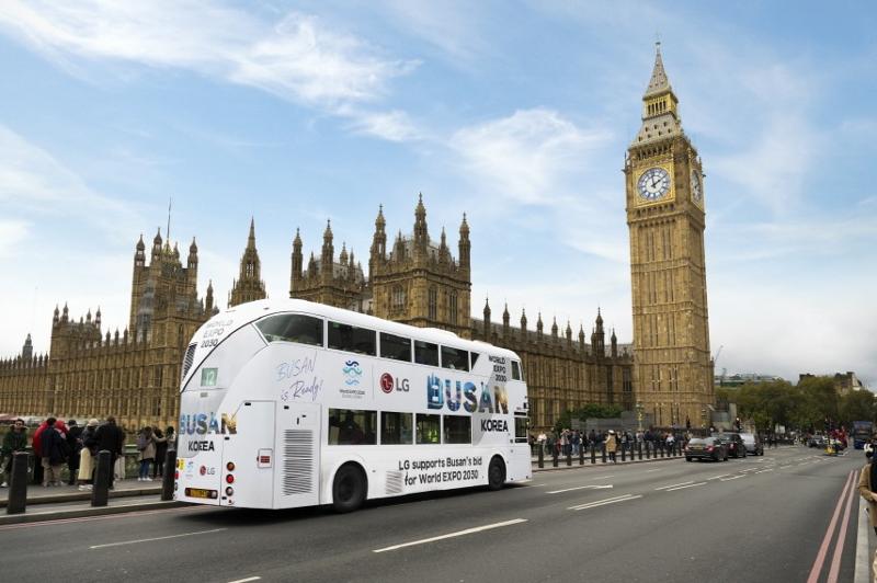 「ＢＵＳＡＮ　ｉｓ　Ｒｅａｄｙ」等、２０３０釜山万博の誘致を応援するフレーズが書かれた「万博バス」が、英国・ロンドンのランドマークであるビッグベンの前を通る様子＝ ＬＧ