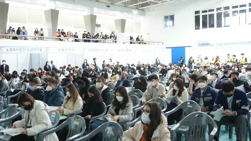大邱大学校体育館で開かれた地域特化型ビザ留学生就職博覧会で、主催側の説明を聞く外国人留学生たち＝２０２３年３月１７日、慶尚北道・大邱、慶尚北道