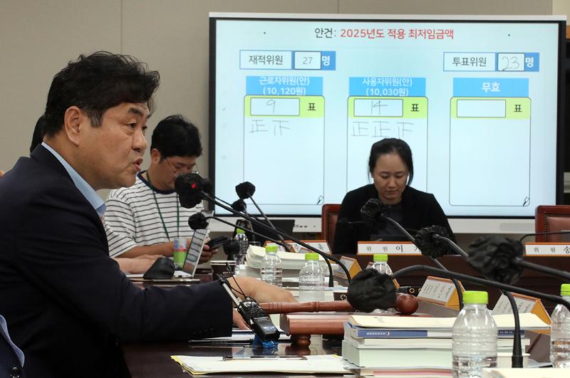 最低賃金委員会が１２日、来年の最低賃金を１万３０ウォンに決めた。写真は、政府世宗庁舎で第１１回全員会議を終えた後、記者の質問に答えるイ・インジェ最低賃金委員長（左）＝１２日、世宗、聯合ニュース