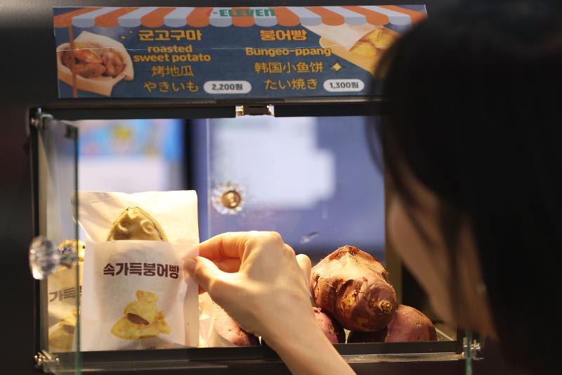 ソウル市内のコンビニでプンオパンを買う観光客＝１１日、ソウル、聯合ニュース