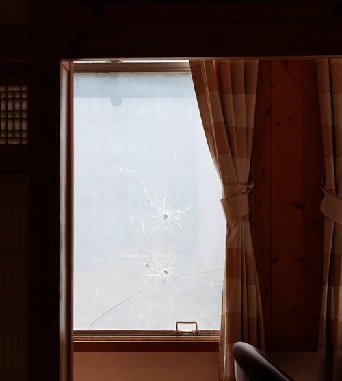 京橋荘の２階の窓に、キム・グ主席が撃たれた銃の跡が再現されている。