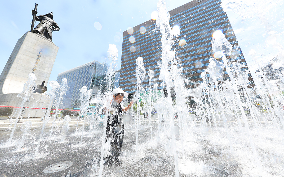 １２日の午後、ソウルの気温は３１度を記録した。写真は、鍾路（チョンノ）区にあるイ・スンシン将軍の銅像前で遊んでいる子供たちの様子。