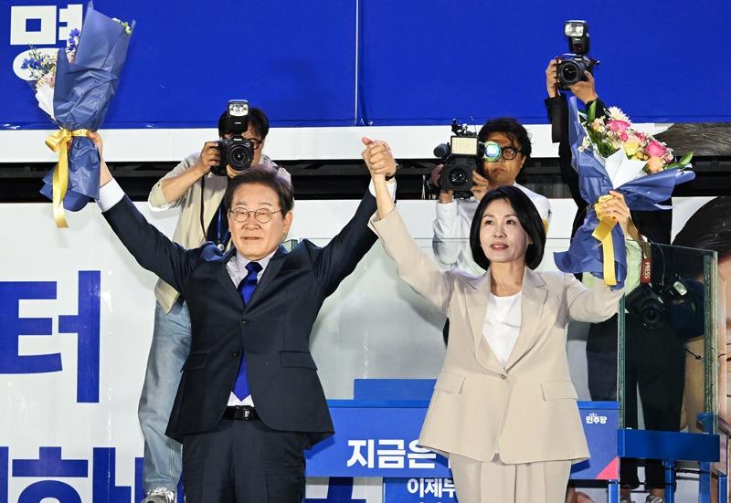 市民に向かって両手を上げて挨拶するイ・ジェミョン候補とキム・ヘギョン夫人=4日,ソウル