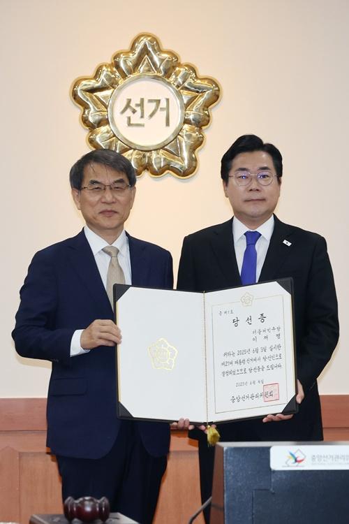 共に民主党のパク・チャンデ院内代表にイ・ジェミョン次期大統領の当選証を渡した後、記念撮影を行うノ・テアク中央選挙管理委員長（左）＝４日、京畿道・果川市