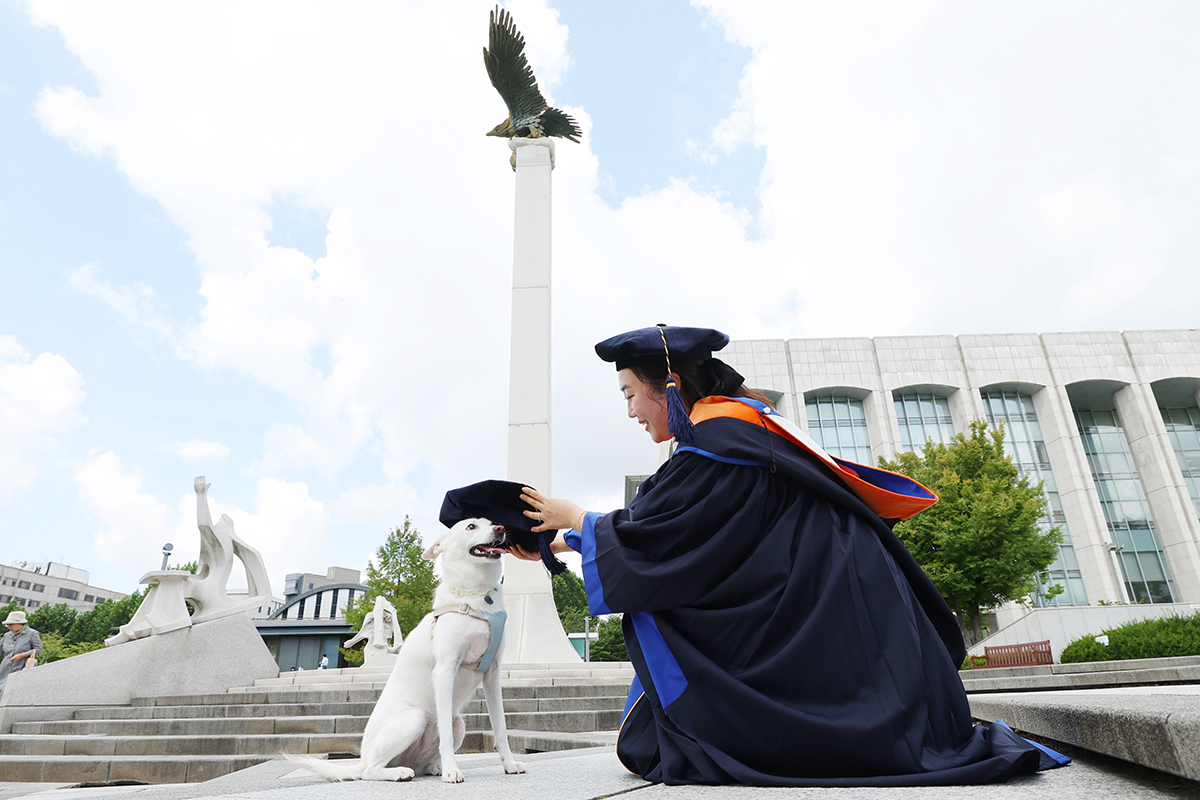 ２９日、ソウルにある延世（ヨンセ）大学校で学位授与式が行われた。写真は、愛犬に学士帽をかぶせる卒業生の様子。
