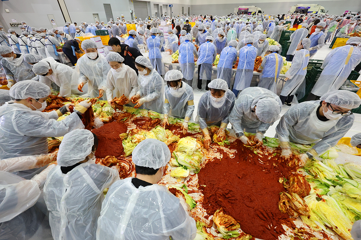 １９日、釜山（プサン）・海雲台（ヘウンデ）区のＢＥＸＣＯ第２展示場で、協賛企業や各種団体、ボランティアら約１０００人が集まり、一人暮らしの高齢者など約６２００世帯に届けるキムチ作りが行われた。