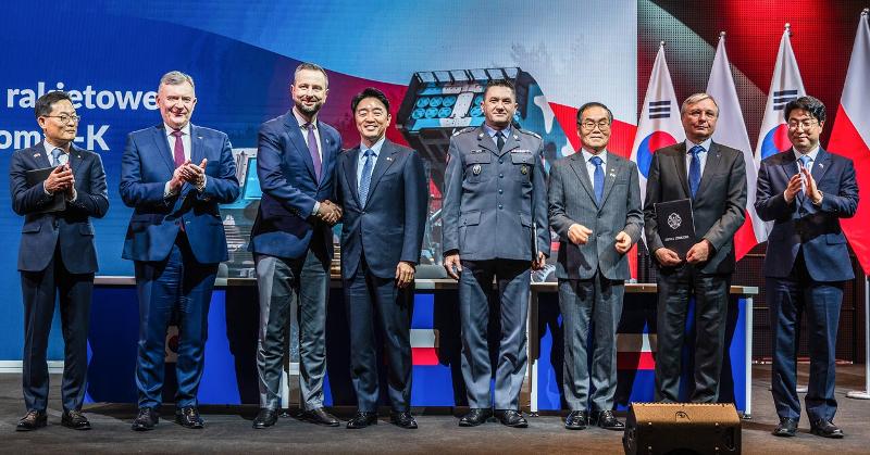 ワルシャワの軍事博物館で開かれた「天武３次実行契約締結式」で、ポーランドのヴワディスワフ・コシニャク＝カミシュ副首相と握手するカン・フンシク大統領府秘書室長（左から４番目）＝２９日（現地時間）、ポーランド、ハンファ・エアロスペース