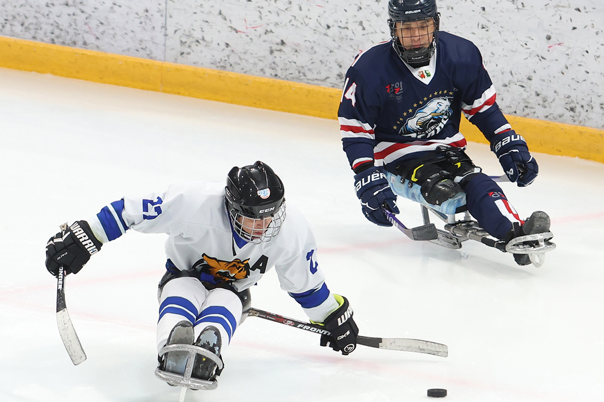 第２３回全国障害者冬季体育大会２日目の２８日、江原（カンウォン）道江陵（カンヌン）ホッケーセンターで、アイスホッケーの江原チーム対忠北（チュンブッ）チームの試合が行われた。写真は、パックを奪い合い激しい攻防を繰り広げる両チームの選手たち。大会は３０日までの４日間、江原道一帯で熱戦が繰り広げられる。