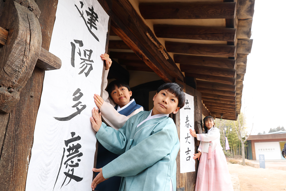 春の始まりを告げる立春（りっしゅん）を迎えた４日、ソウル・国立民俗博物館の裏門で、子どもたちが立春の書き初めを門に貼る姿が見られた。『立春大吉 建陽多慶』という言葉には、一年の幸運と豊作を願う新しい季節への希望が込められている。
