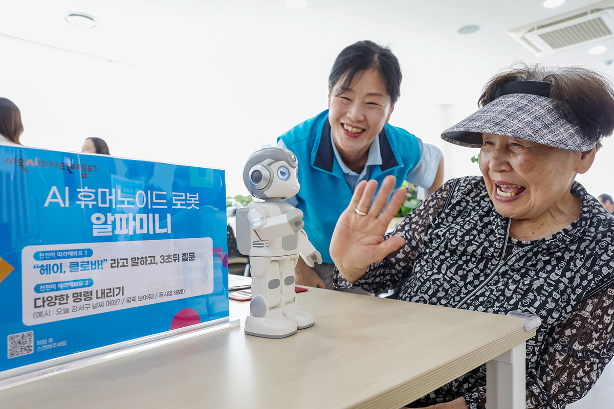 老人福祉センターの「ＡＩデジタル学び場」で高齢者が人工知能（ＡＩ）ヒューマノイドロボット「アルファミニ」との会話を楽しむ様子＝５月２８日、ソウル