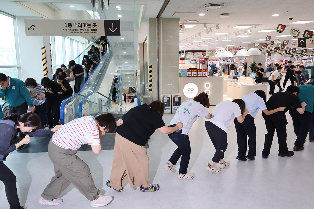 ２０日、釜山市・釜山鎮（プサンジン）区のスーパーで空襲に備えた「民防衛訓練」が行われた。写真は、空襲警報の発令を受け、区役所職員や従業員、利用客らが誘導に従って避難している様子。
