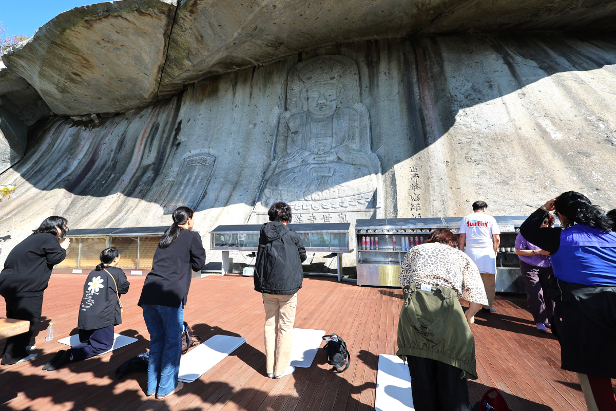 ２０２７学年度大学修学能力試験を３０日後に控えた２０日、仁川（インチョン）広域市の普門寺（ポムンサ）にある磨崖石仏坐像の前で、受験生の子どもを持つ保護者や仏教徒らが合格を願って祈りを捧げる様子。